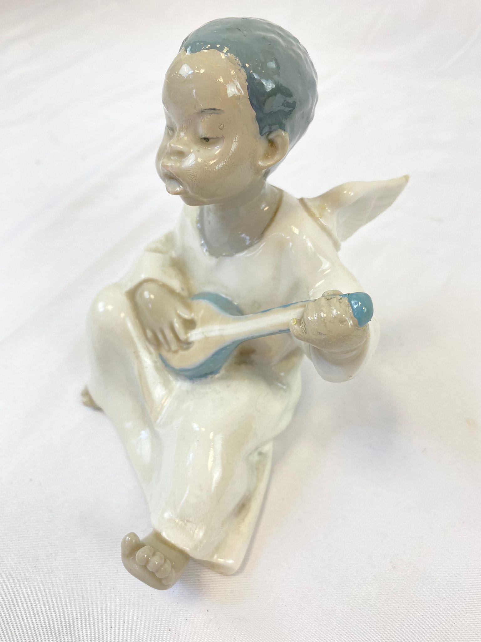 A Lladro figure of a sitting, black boy angel. Hand made in Spain. Height: 11 cm. - Image 2 of 3