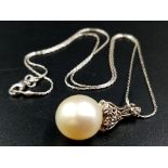 A beautiful white spherical pearl (12 mm) pendant on a 14 K white gold Italian chain. Length: 43 cm.