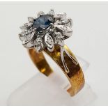 An 18K Yellow Gold Diamond and Sapphire Ring. Central sapphire surround by a halo of diamond petals.