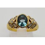 An 18 K yellow gold ring with an oval cut aquamarine and diamonds on the shoulders. Ring size: P,