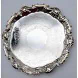 A HALLMARKED SILVER FOOTED PLATTER DATED 1745 WITH SHELL AND SCROLL EDGING. 452gms 24cms diameter