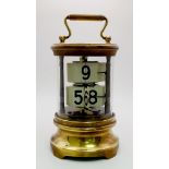 A 1930s Ever Ready Plato Flip Clock. Made with cylindrical brass and in a glass case. 17cm tall.