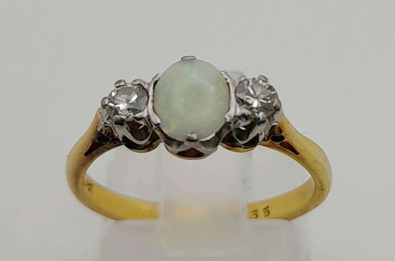 An 18 K yellow gold ring with an opal cabochon and two brilliant cut diamonds. Ring size: L, weight: