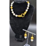 An unusual, Chinese, white jade necklace and earrings set with an 18 K yellow gold plated twin