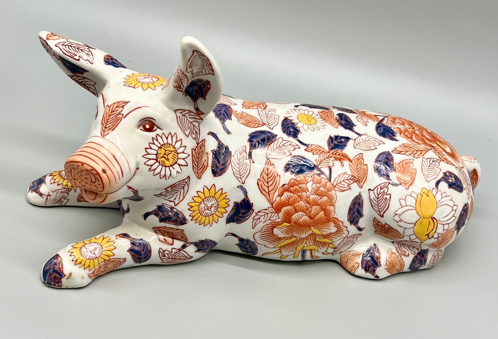 A Japanese, IMARI, ceramic pig, modelled recumbent, with six character mark to base. (Valuation at