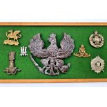 Framed display of original WW1 cap badges including an Imperial German Pickelhaube Wappen Plate