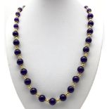 A Graduated Purple Jade Beaded Necklace - With gilded spacers and clasp. 48cm.