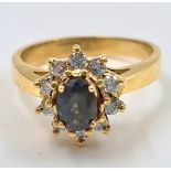 A GREEN ALEXANDRITE STONE SET IN 18K GOLD SURROUNDED BY BRIGHT DIAMONDS. 4.2gms size M