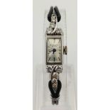 a vintage Jules Jorgenson 14k white gold ladies wrist watch with diamond shoulders.