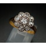 An 18K Yellow Gold (tested) Diamond Floral Ring. Nine diamonds creating the perfect daisy. Size O.