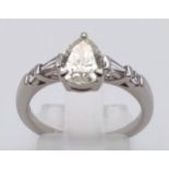 A STUNNING 1.1CT PEAR SHAPED DIAMOND SET IN PLATINUM WITH DIAMOND BAGUETTE AND ROUND DIAMOND