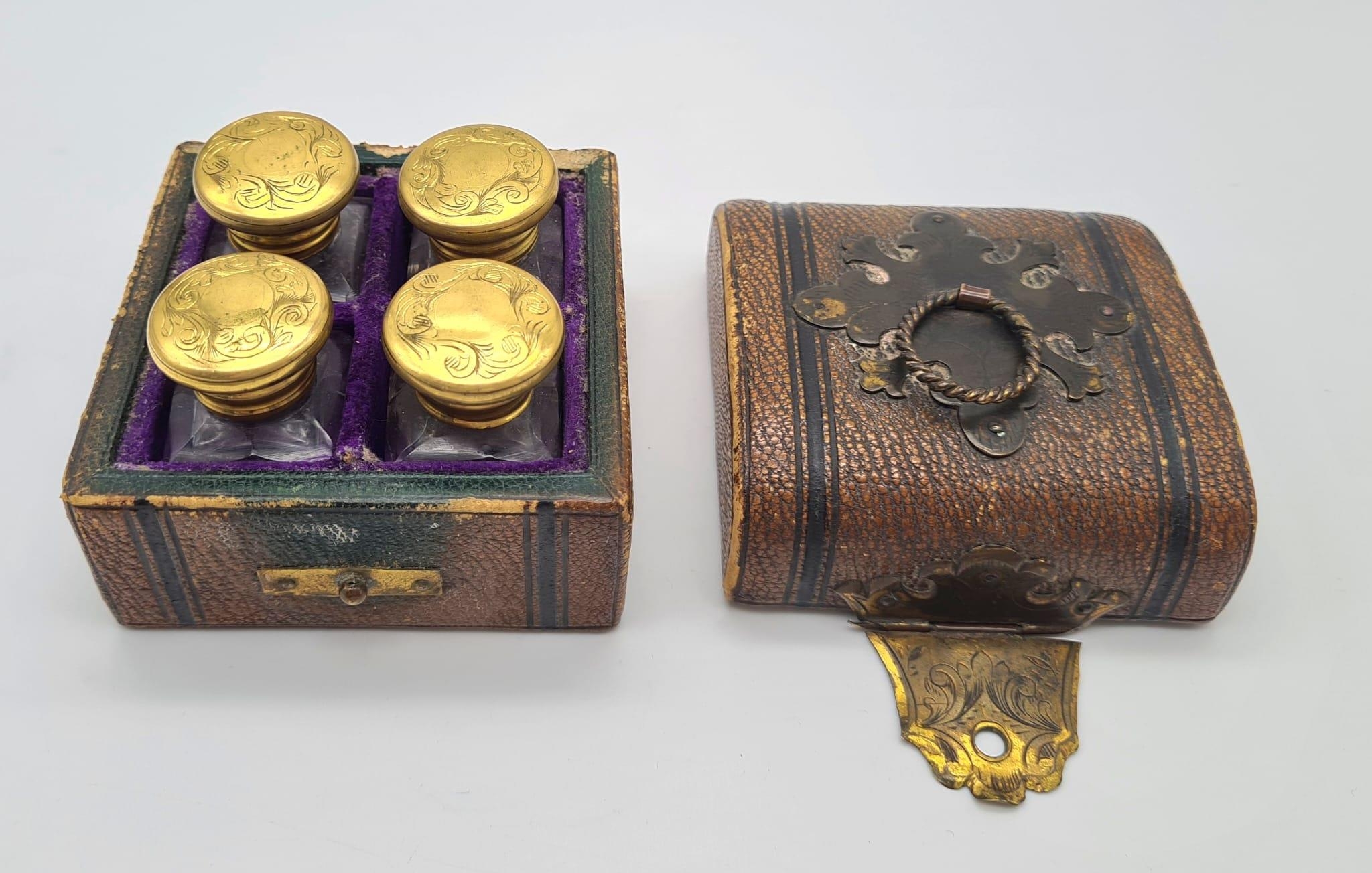 A VICTORIAN SET OF 4 GILT TOPPED PERFUME BOTTLES IN ORIGINALCARRYING BOX (BOX NEEDS HINGE ATTENTION)