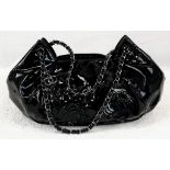 A Chanel Camelia Black Leather Patent Bag. Flap detail, silver and leather interwoven chain