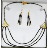 A very elegant, black, faceted, spinel necklace and earrings set in a presentation case. Hand cut