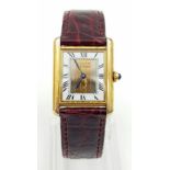A LADIES CARTIER TANK WATCH IN GOLD PLATED SILVER WITH ORIGINAL CARTIER BURGUNDY STRAP, COMES WITH
