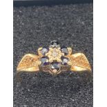 9 carat GOLD, SAPPHIRE and DIAMOND RING having diamond point to centre with six sapphire surround,