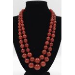 An 1100ct Graduated Double-Strand Sunset-Red Agate Bead Necklace. 44cm. Largest bead - 18mm.