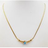 A 9K Yellow Gold Blue Topaz and Diamond Drop Pendant Necklace. Central topaz with three diamonds