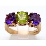 A 9K Yellow Gold Amethyst and Peridot Three Stone Ring. Size N. 4.38g total weight.