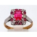 A 9K Yellow Gold Ruby and Diamond Ring. Large central Ruby surrounded by smaller rubies and