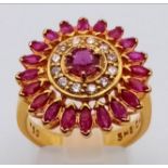 An 18K Yellow Gold Ruby and Diamond Ring - Central ruby surrounded by a halo of diamonds in turn