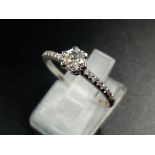 A 9K White Gold Diamond Ring. Central diamond with diamonds on shoulders. 0.35 and 0.20ct. Size O.