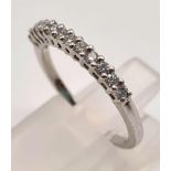 An 18K White Gold Diamond Half-Eternity Ring. Twelve diamonds - 0.60ct. Size L. 2.23g total weight.