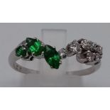 A 9K White Gold Chevron Emerald and Diamond Ring. 3 Emeralds and 7 Diamonds. Size R. Total weight: