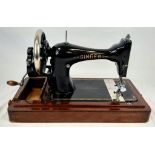 An Antique Singer Manuel Wind Sewing Machine. In wooden Case. 46 x 33cm. A/F.