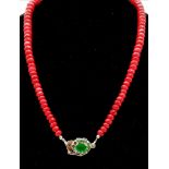A single strand necklace of graduating faceted African rubies (280 carats) with a silver emerald
