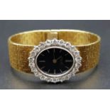 An 18 K rose gold PIAGET ladies watch. Oval dial 28 x 25 mm, black face, white gold bezel with