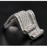 An 18 K white gold ring with two scrolls loaded with baguette and brilliant cut diamonds. Ring size: