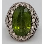 A Vintage Breath-Taking 15ct Peridot Silver Ring. Large peridot encased in a pierced silver