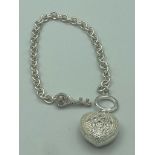 Ladies chain link bracelet, having large heart pendant and ‘T’ bar fastening in the form of a key.