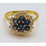 A Gorgeous 18K Yellow Gold Sapphire and Diamond Ring. Seven clean sapphires surrounded by 18 small