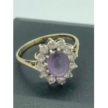 9 carat GOLD RING with cushion cut oval AMETHYST set to top with clear zirconia stone surround.