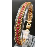 An 18k Yellow Gold and Ruby Tennis Bracelet. Rope links either sider of 47 rubies. 17cm. 14.89g