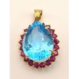 A 14K Yellow Gold Large Topaz and Ruby Pendant. 7.93g total weight. Large bright topaz surrounded by