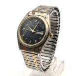 Wrangler watch with expandable strap, black face with gold tone numbers, day and date windows, in