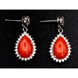 A glamorous pair of 18ct white gold earrings with polished natural red coral and diamonds (1.5