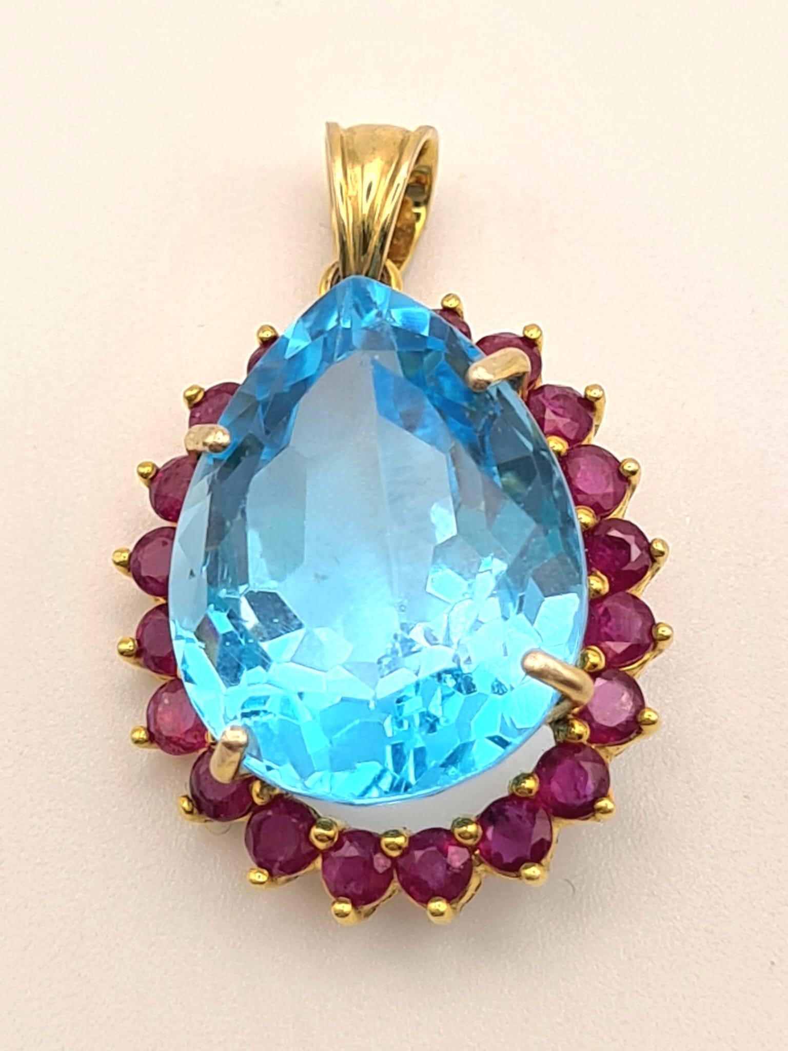 A 14K Yellow Gold Large Topaz and Ruby Pendant. 7.93g total weight. Large bright topaz surrounded by