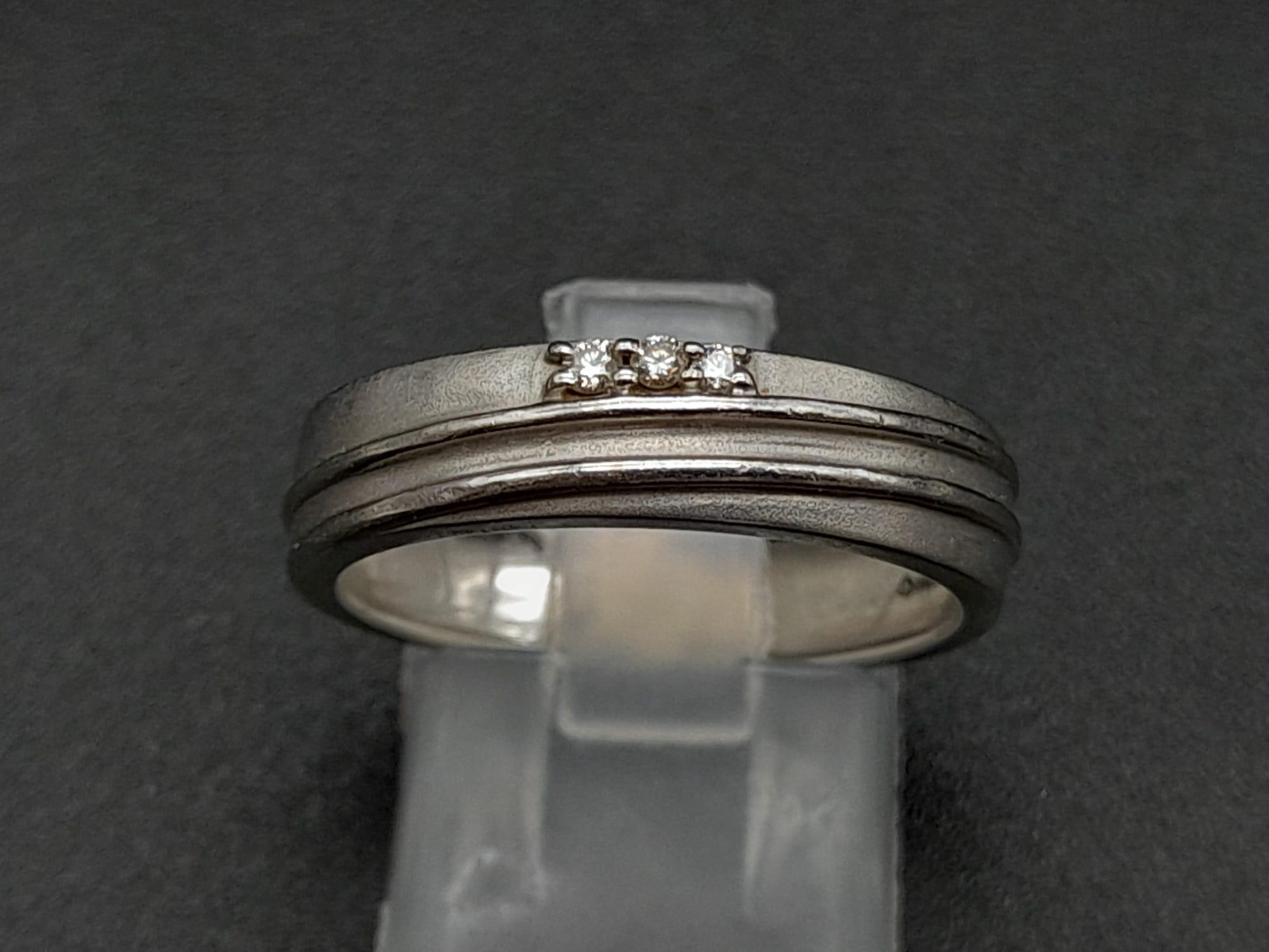 A 950 Platinum Diamond Band Ring. Three small diamonds. Size Q. 5.19g total weight. Ref - 190
