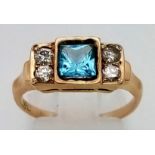 An 18K Yellow Gold Topaz and Diamond Ring. Central square cut topaz with two diamonds either side.