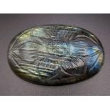An oval carved labradorite (113.95 carats) with GLA certificate. Dimensions: 49.70 x 32.86 x 8.28