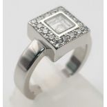An 18K White Gold Floating Diamond Ring. A square of diamonds shield a central floating diamond.