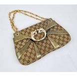 A Gucci Dionysus Dragons Head Handbag. Beige monogrammed cloth with gilded touches and hardware.