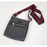 A Black and Grey Gucci Supreme Messenger Bag. Monogrammed canvas exterior. Blue and red cloth strap.