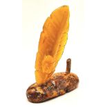 An Antique Large Amber Figure. Polish in origin, this piece has a polished raw amber base with a