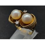 An 18K Yellow Gold Pearl and Diamond Ring. Two round brilliant cut natural diamonds and two near-