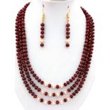 A three strand necklace with multifaceted rubies and genuine pink pearls with a complimenting